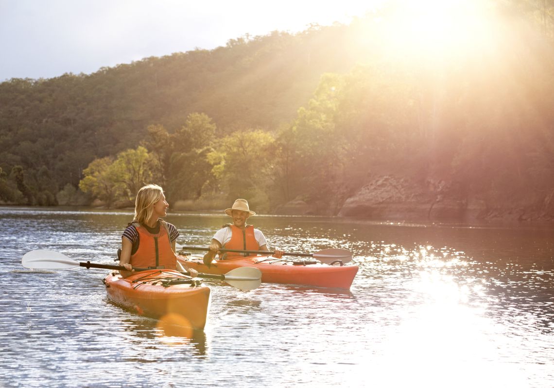 Couple enjoying a day of kayaking along Hawkesbury River, near Lower MacDonald