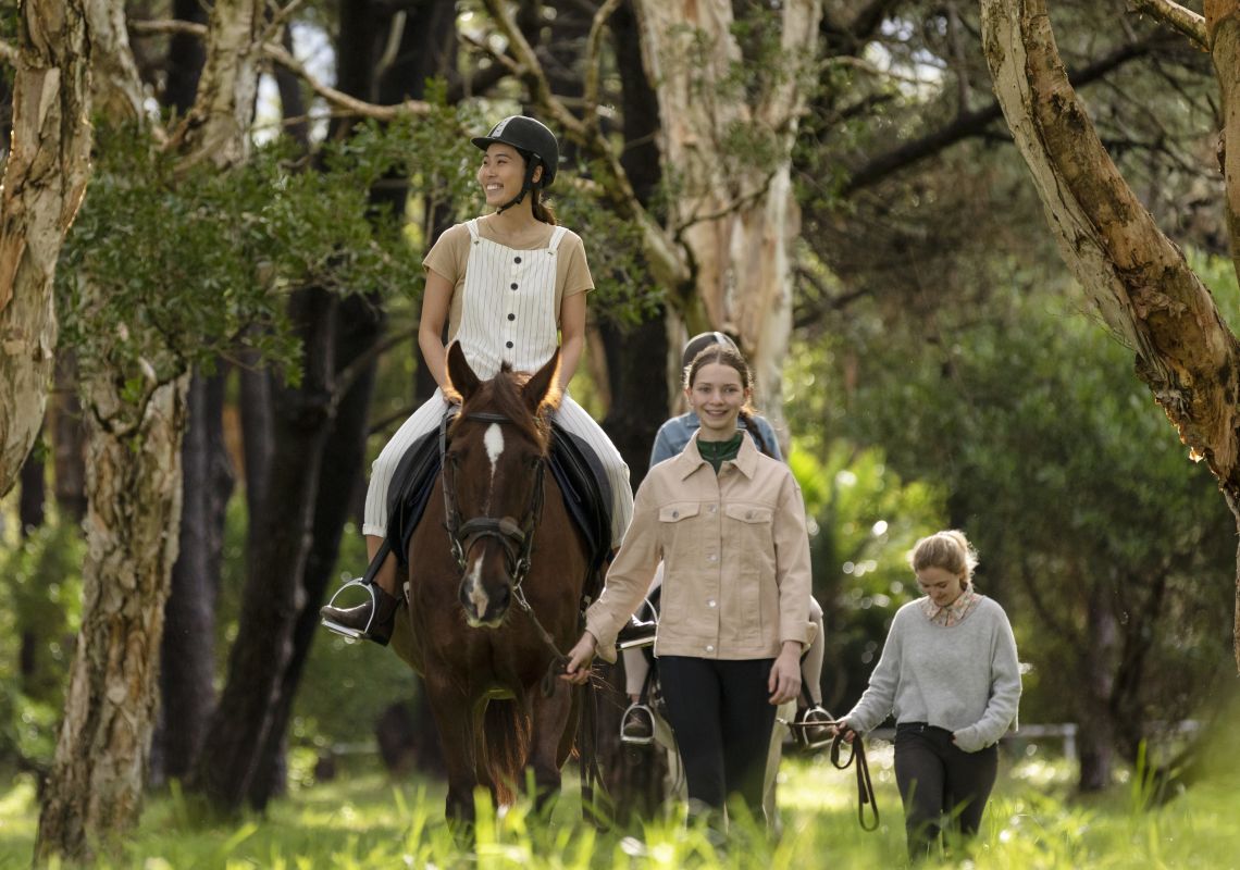 Woman enjoying a horse riding experience with East Side Riding Academy in Centennial Park, Sydney