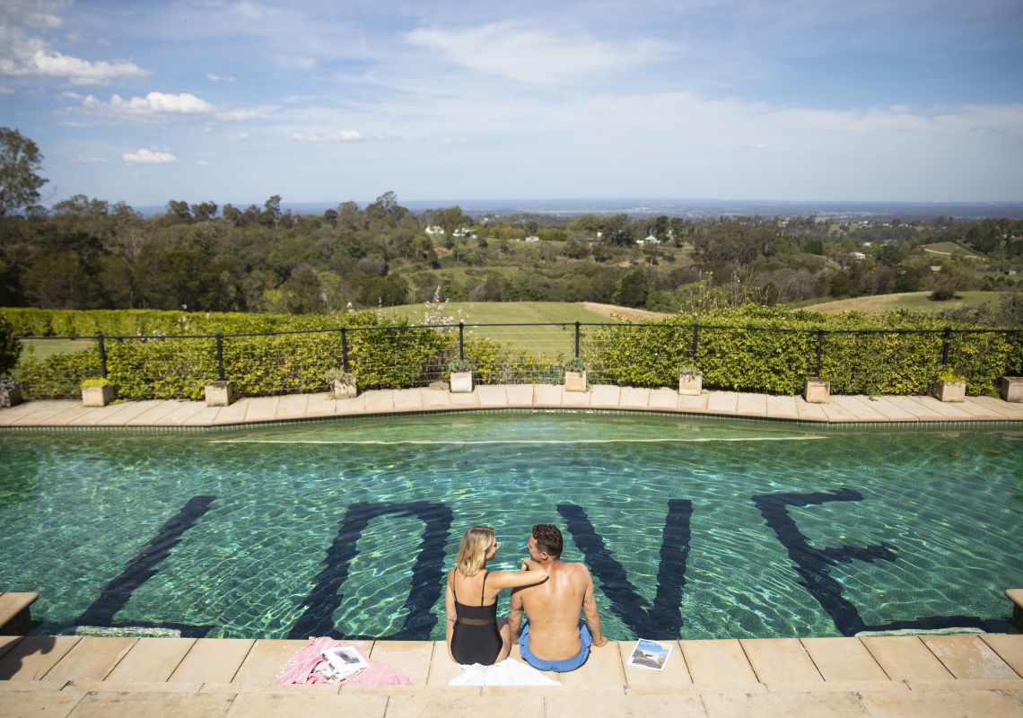 Couple enjoying a swim with views across the Hawkesbury Valley at Loxley On Bell Bird Hill, Kurrajong Hills