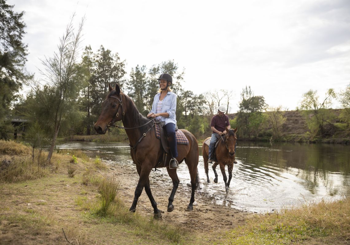 Couple enjoying a horseriding experience along the Hawkesbury River with Hawkesbury Valley Equestrian Centre