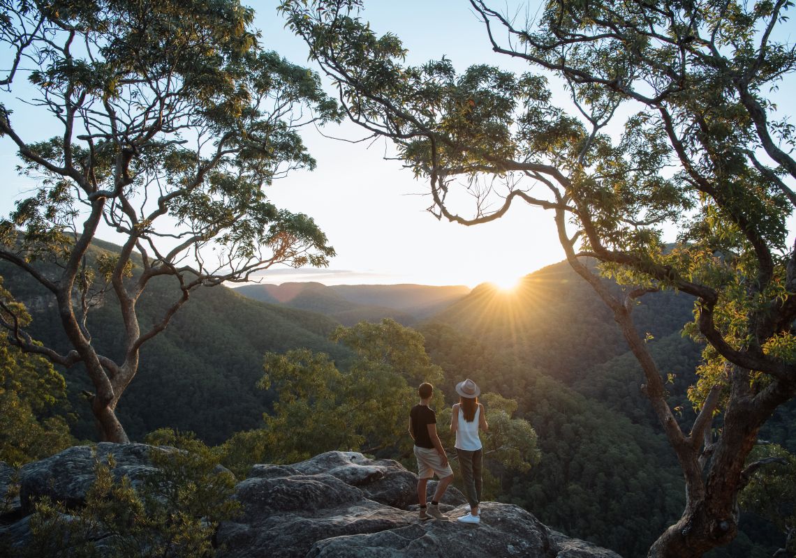Couple enjoying a scenic sunset over the Hawkesbury Valley from the Vale of Avoca lookout in Grose Vale