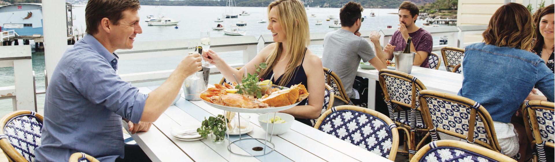 A couple dinning along a harbor