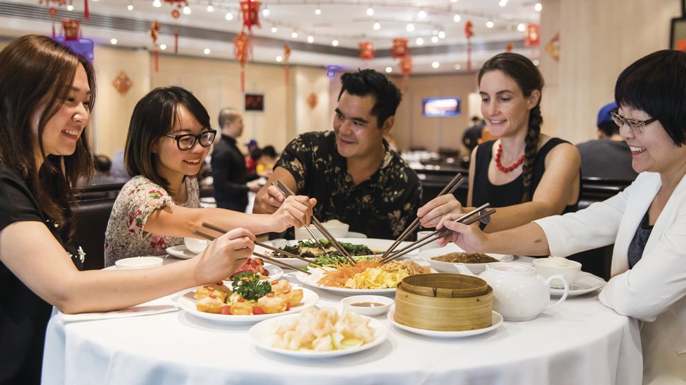 Friends enjoying a prosperity toss at Golden Century Restaurant, Chinatown during Chinese New Year 2018