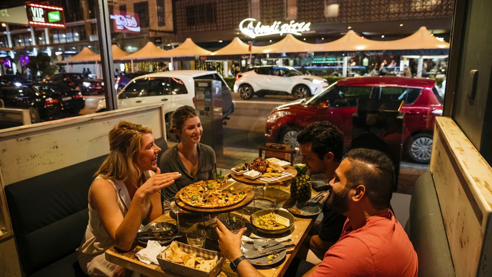 Friends enjoying food and drink at Mama and Papas restaurant along Eat Street dining precinct in Parramatta