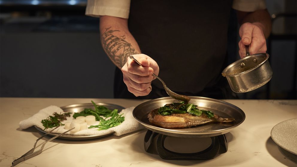 Chef de Cuisine, Rob Cockerill placing the finishing touches on a dish at Bennelong Restaurant, Sydney