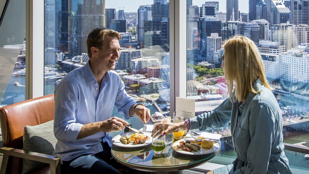 Couple enjoying food and drink at Club Millésime inside Sofitel in Darling Harbour, Sydney City