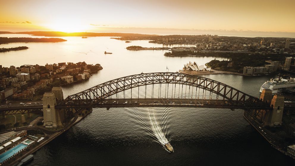 Aerial of the sun rising over Sydney Harbour with views of the Sydney Harbour Bridge