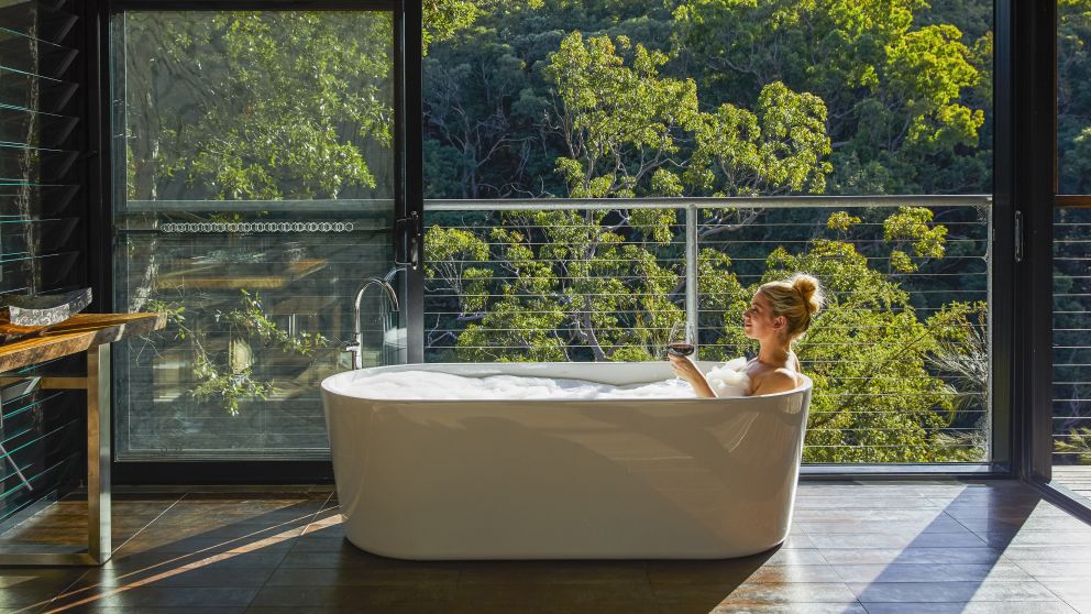 Woman relaxing in the bath with views at Spicers Sangoma Retreat, Bowen Mountain