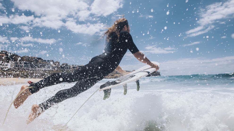 Surfer heading out to catch a wave at Bronte Beach, Sydney