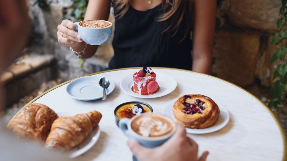 Woman enjoying coffee and pastries at La Renaissance Patisserie and Cafe in The Rocks, Sydney City