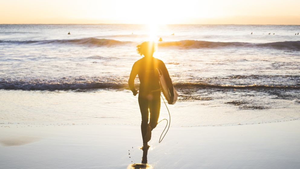 Man heading into the surf at Whale Beach on Sydney's Northern Beaches