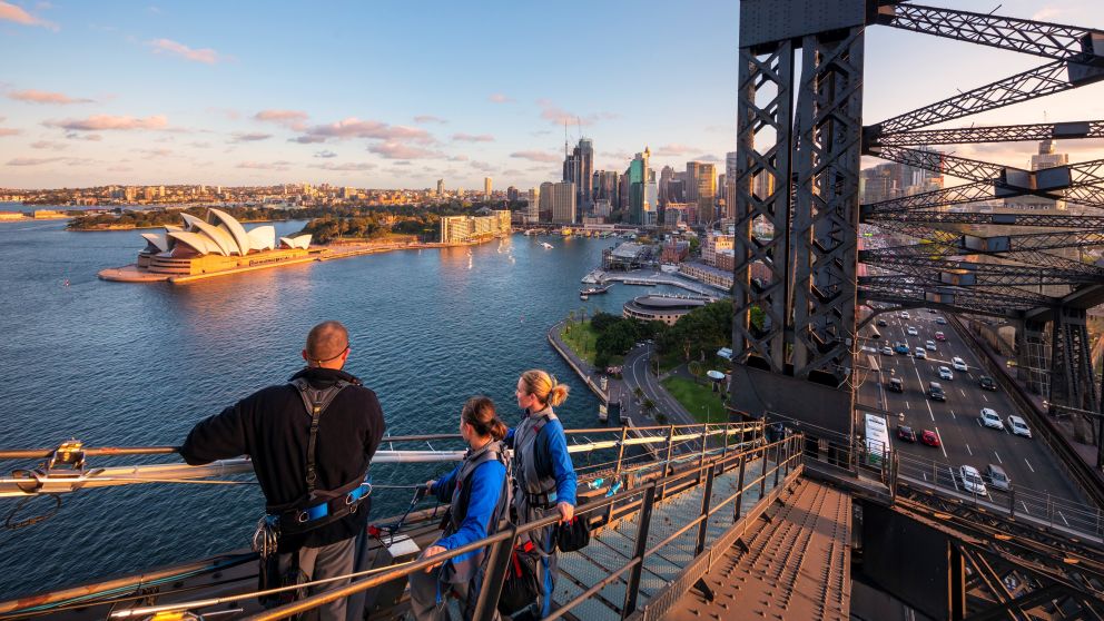 Friends enjoying a twilight BridgeClimb Sydney experience overlooking Sydney Harbour