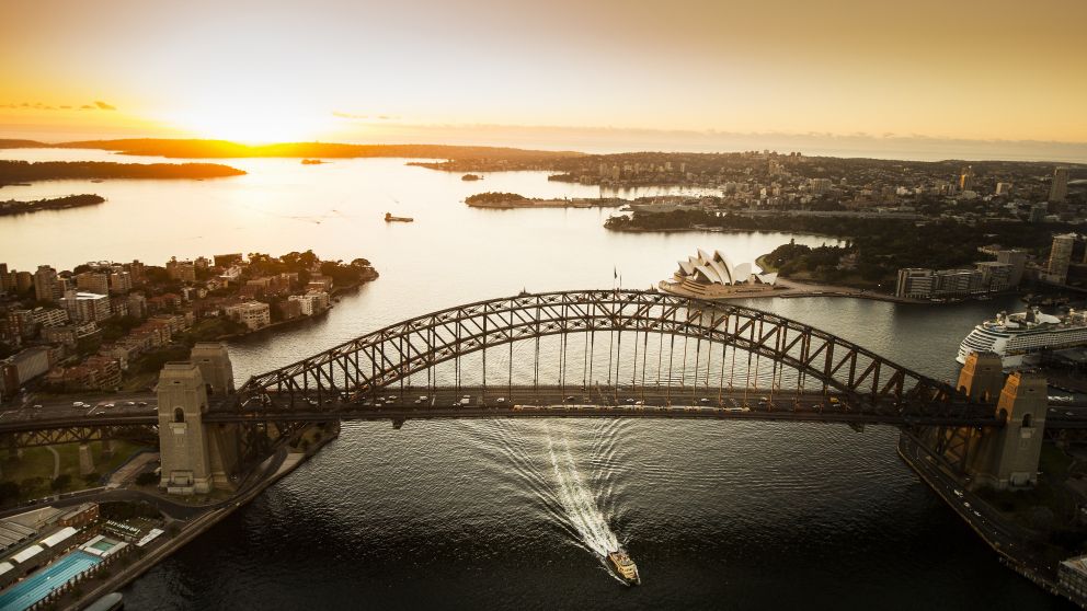 Aerial of the sun rising over Sydney Harbour with views of the Sydney Harbour Bridge