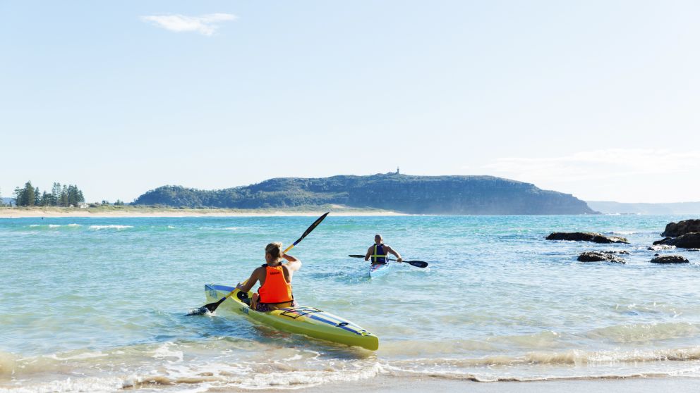 Couple enjoying a morning paddle at Palm Beach on Sydney's northern beaches