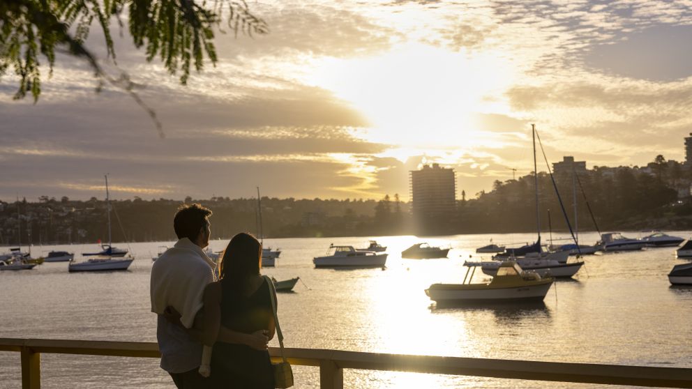 Couple watching the sun setting over North Harbour, Manly