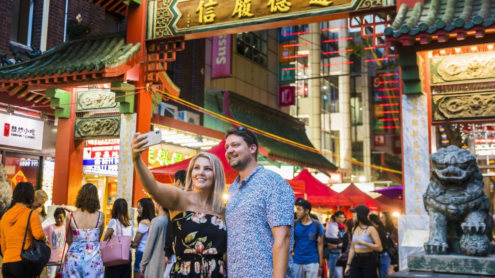 Couple take a selfie in front of the Chinatown gates on Dixon Street, Sydney City