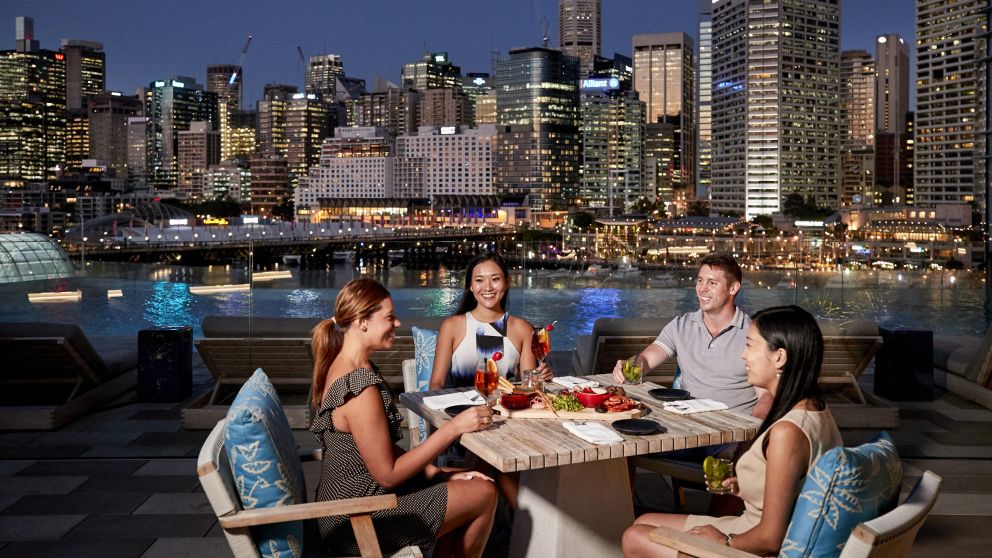 Guests enjoying food and drink at Le Rivage Pool Bar, Sofitel with stunning views across Darling Harbour