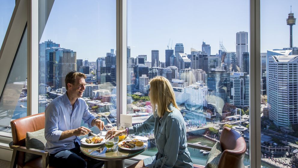 Couple enjoying food and drink at Club Millésime inside Sofitel in Darling Harbour, Sydney City