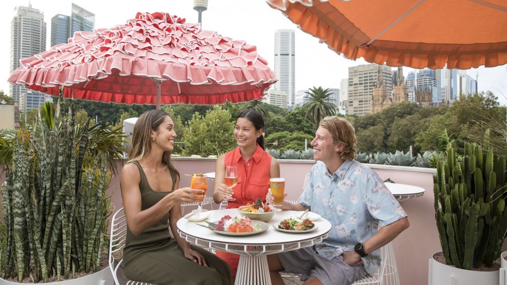 Friends enjoying sushi and refreshing cocktails available from Slims Rooftop, Darlinghurst