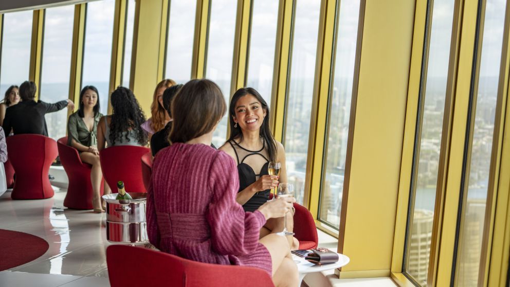 Friends enjoying drinks with views across Sydney from Bar 83 at Sydney Tower, Sydney CBD