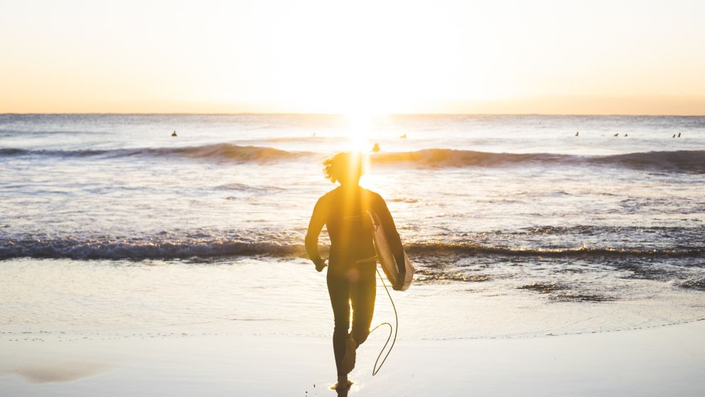 Man heading into the surf at Whale Beach on Sydney's Northern Beaches