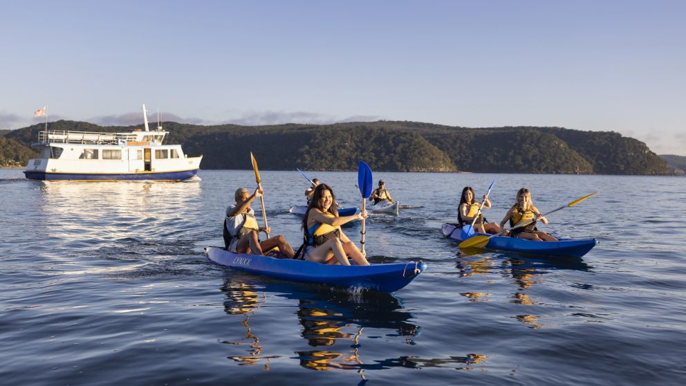 Friends enjoying a sunrise kayaking experience in Pittwater with Pittwater Kayak Tours, Palm Beach