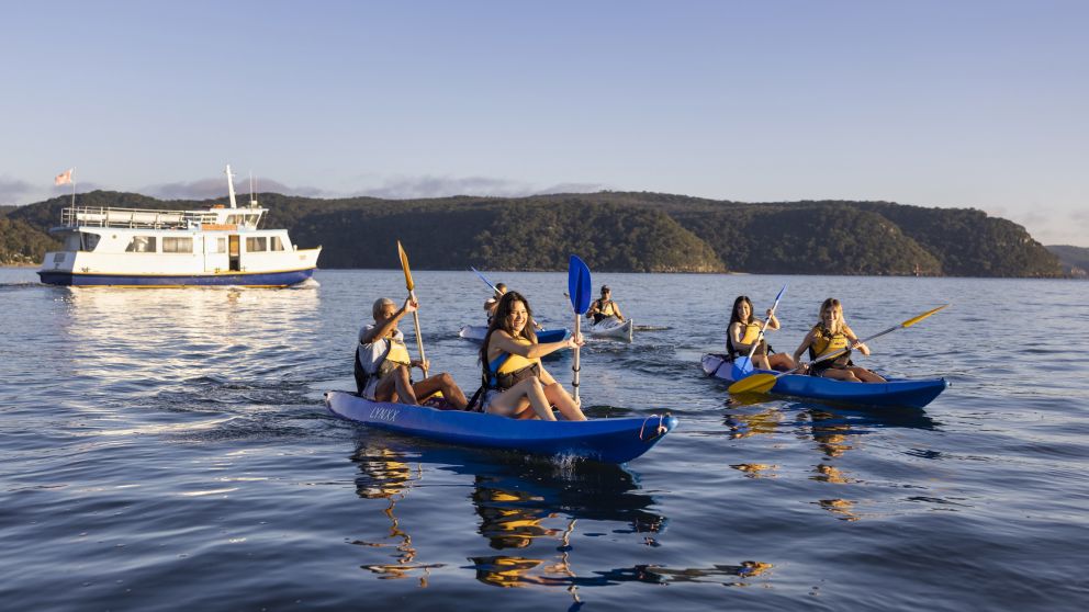 Friends enjoying a sunrise kayaking experience in Pittwater with Pittwater Kayak Tours, Palm Beach