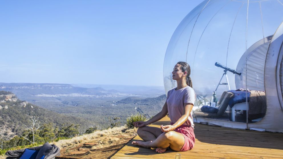 Woman relaxing by her Bubbletent Australia accommodation in the Capertee Valley