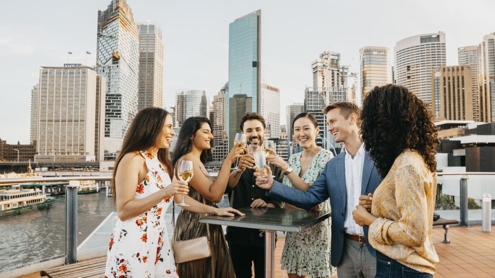 Friends enjoying rooftop drinks in The Rocks with views of Sydney Harbour