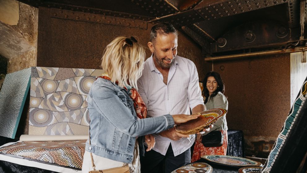 Couple browsing through Aboriginal artwork for sale at the Blak Markets on Bare Island, La Perouse