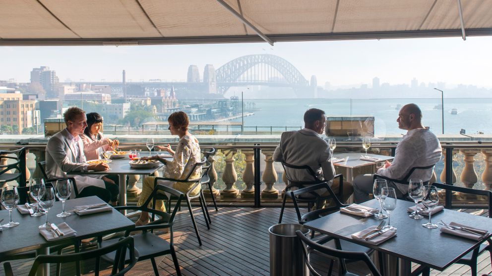 Diners enjoying food and drink with harbour views at Cafe Sydney, Sydney