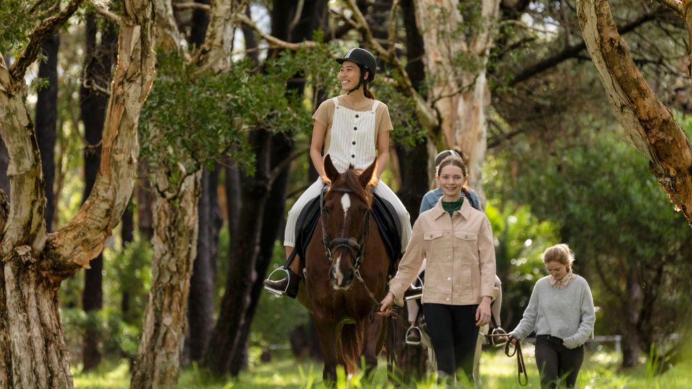 Woman enjoying a horse riding experience with East Side Riding Academy in Centennial Park, Sydney