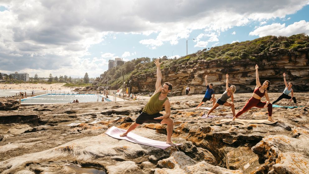 Group enjoying a yoga session by the ocean, Freshwater Beach