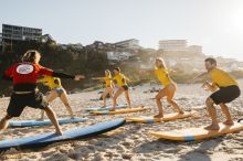 Adults enjoying a learn to surf experience with Manly Surf School at Freshwater Beach