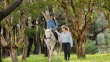 Eine Frau genießt einen Ausritt mit der Eastside Riding Academy im Centennial Park in Sydney.