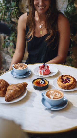 Woman enjoying coffee and pastries at La Renaissance Patisserie and Cafe in The Rocks, Sydney City