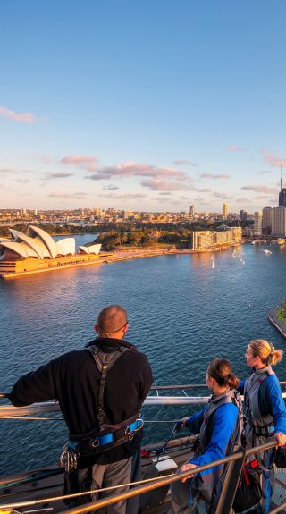 Friends enjoying a twilight BridgeClimb Sydney experience overlooking Sydney Harbour