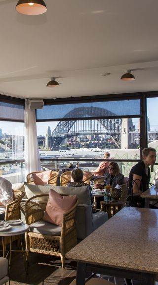 People enjoying food and drink at Henry Deane's rooftop cocktail lounge, Hotel Palisade, Millers Point