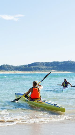 Couple enjoying a morning paddle at Palm Beach on Sydney's northern beaches