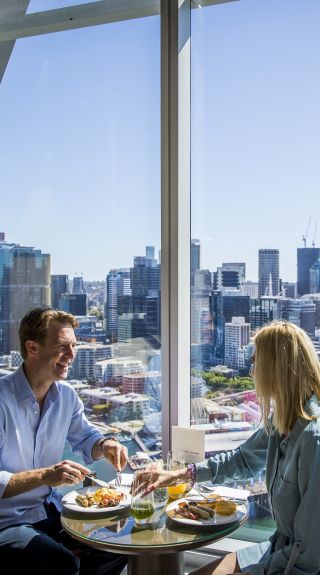 Couple enjoying food and drink at Club Millésime inside Sofitel in Darling Harbour, Sydney City