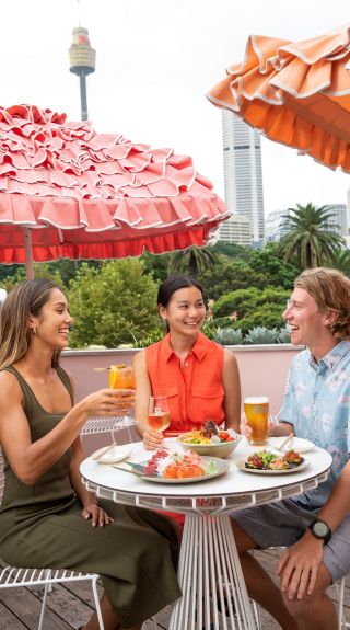 Friends enjoying sushi and refreshing cocktails available from Slims Rooftop, Darlinghurst