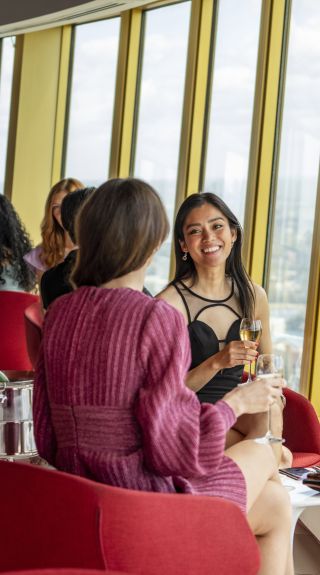 Friends enjoying drinks with views across Sydney from Bar 83 at Sydney Tower, Sydney CBD