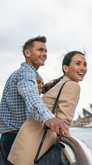 Couple enjoying harbour views aboard a Captain Cook Cruises vessel in Sydney Harbour, Sydney City