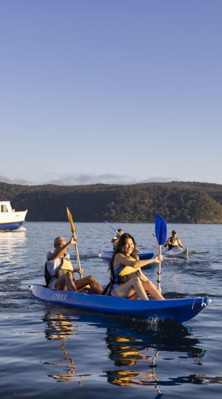 Friends enjoying a sunrise kayaking experience in Pittwater with Pittwater Kayak Tours, Palm Beach