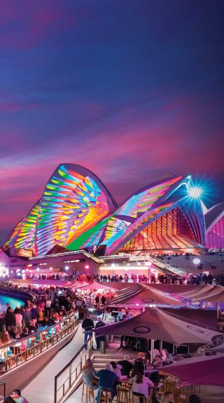 Patrons at Opera Bar enjoying the sunset and light projections during Vivid Sydney 2018