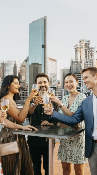 Friends enjoying rooftop drinks in The Rocks with views of Sydney Harbour