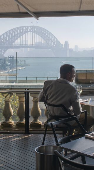 Diners enjoying food and drink with harbour views at Cafe Sydney, Sydney