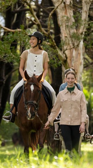 Woman enjoying a horse riding experience with East Side Riding Academy in Centennial Park, Sydney