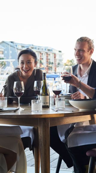 Friends enjoying food and drink at waterside, LuMi Bar & Dining, Pyrmont