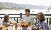 Family enjoying food and drink at The Newport with scenic views of Pittwater, Newport